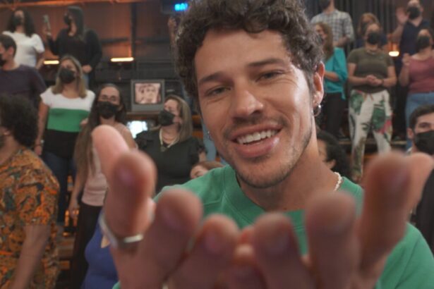 José Loreto sorrindo, enviando beijo para o público, de camisa verde durante gravação do Altas Horas, da TV Globo