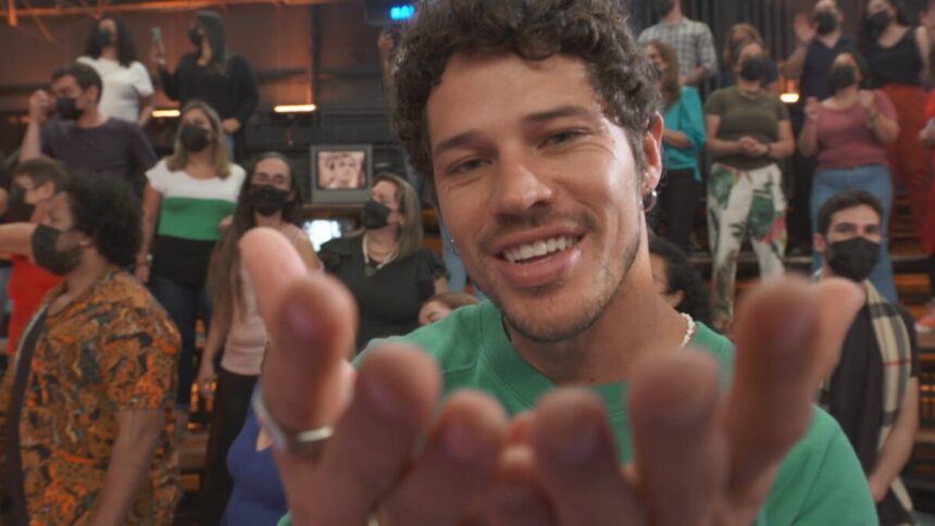 José Loreto sorrindo, enviando beijo para o público, de camisa verde durante gravação do Altas Horas, da TV Globo