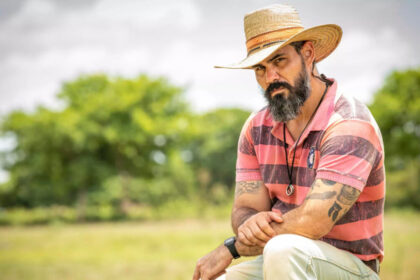 Juliano Cazarré de chapéu em cena de Pantanal