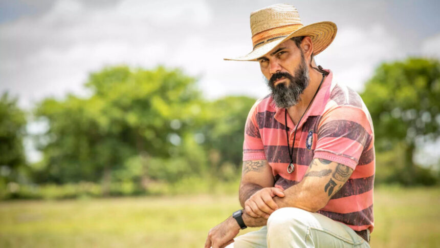 Juliano Cazarré de chapéu em cena de Pantanal