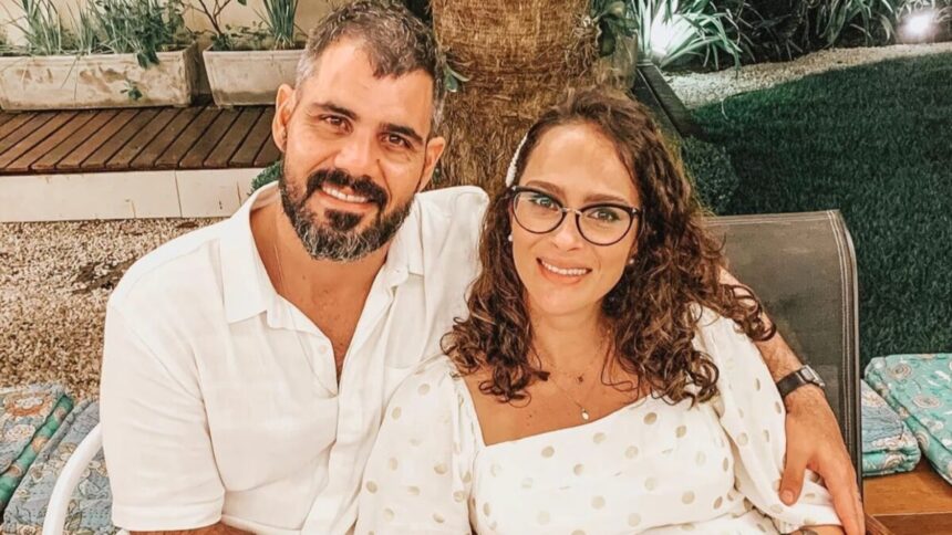 Juliano Cazarré e a esposa Letícia Cazarré sorrindo, de camisa branca durante fotos para as redes sociais