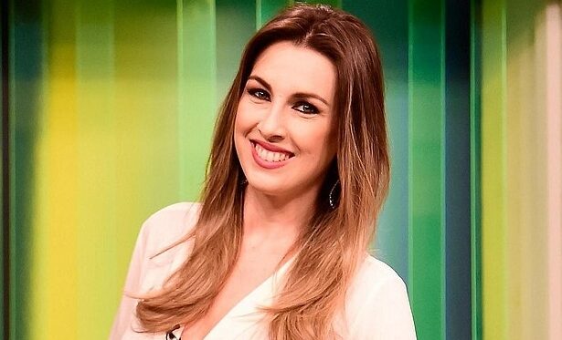 Michelle Giannella de camisa branca, sorrindo, microfone na camisa, durante gravação de programa na TV Gazeta