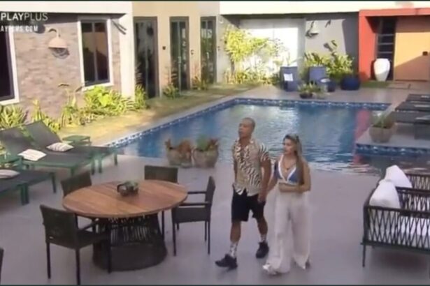 Karol e Mussunzinho na área externa do Power Couple, próximos da piscina.