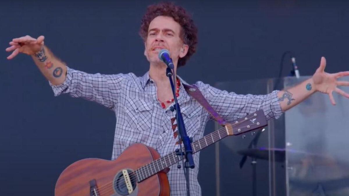 Nando Reis com violão em cima de um palco
