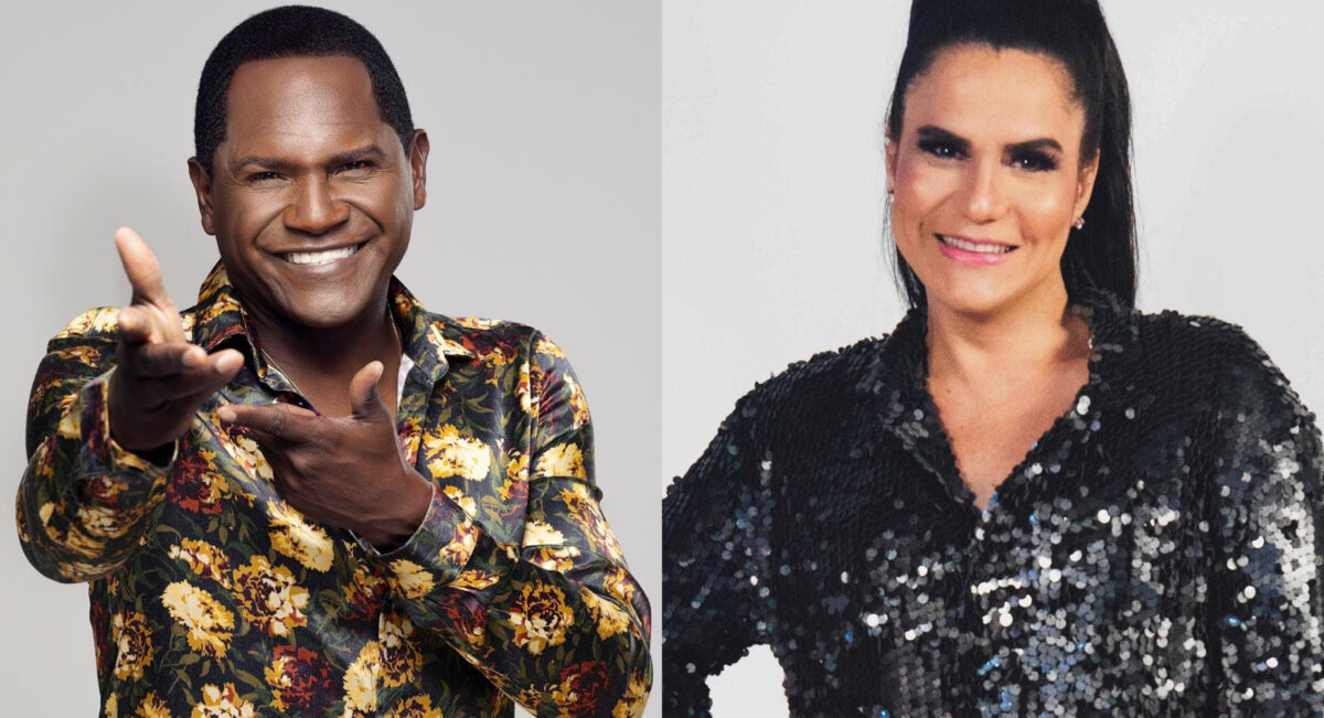 Tatau sorrindo com camisa estampada e mãos pra frente; Gilmelandia de camisa preta brilhosa, sorrindo, cabelo preso para ensaio fotográfico