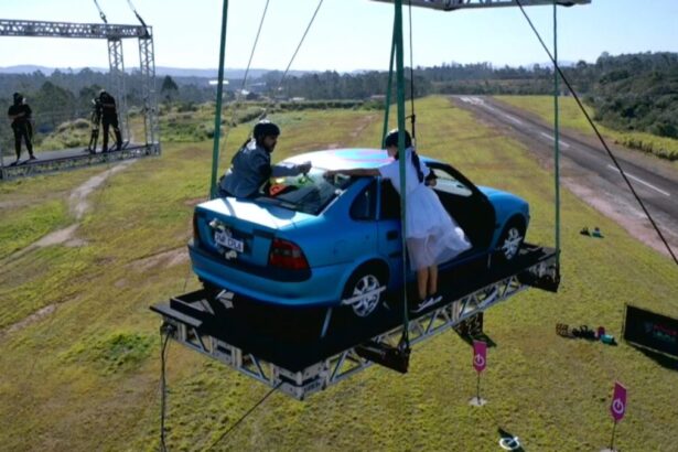 Na imagem aparece um carro pendurado por guindaste para a Prova dos Casais.