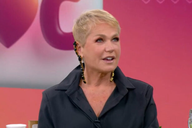 Xuxa Meneghel nos estúdios do Mais Você, com o telão ao fundo, tendo o logo do programa projetado