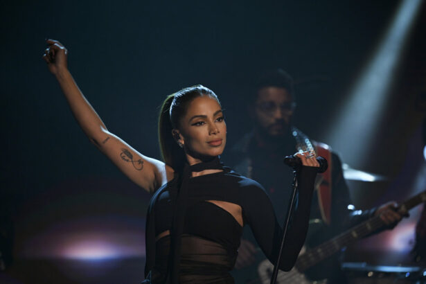 Anitta estende o braço direito em apresentação no programa The Tonight Show