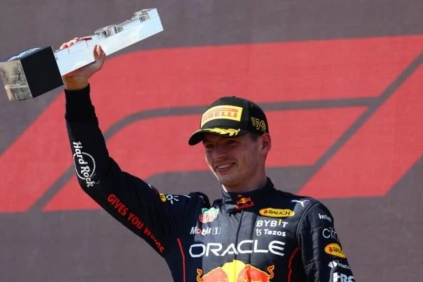 Max Verstappen no pódio da Fórmula 1, erguendo a o troféu da vitória