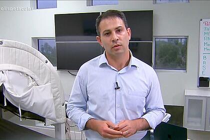 André Tal com camisa social azul clara dentro de um consultório nos Estados Unidos gravando matéria para o Domingo Espetacular, da Record TV