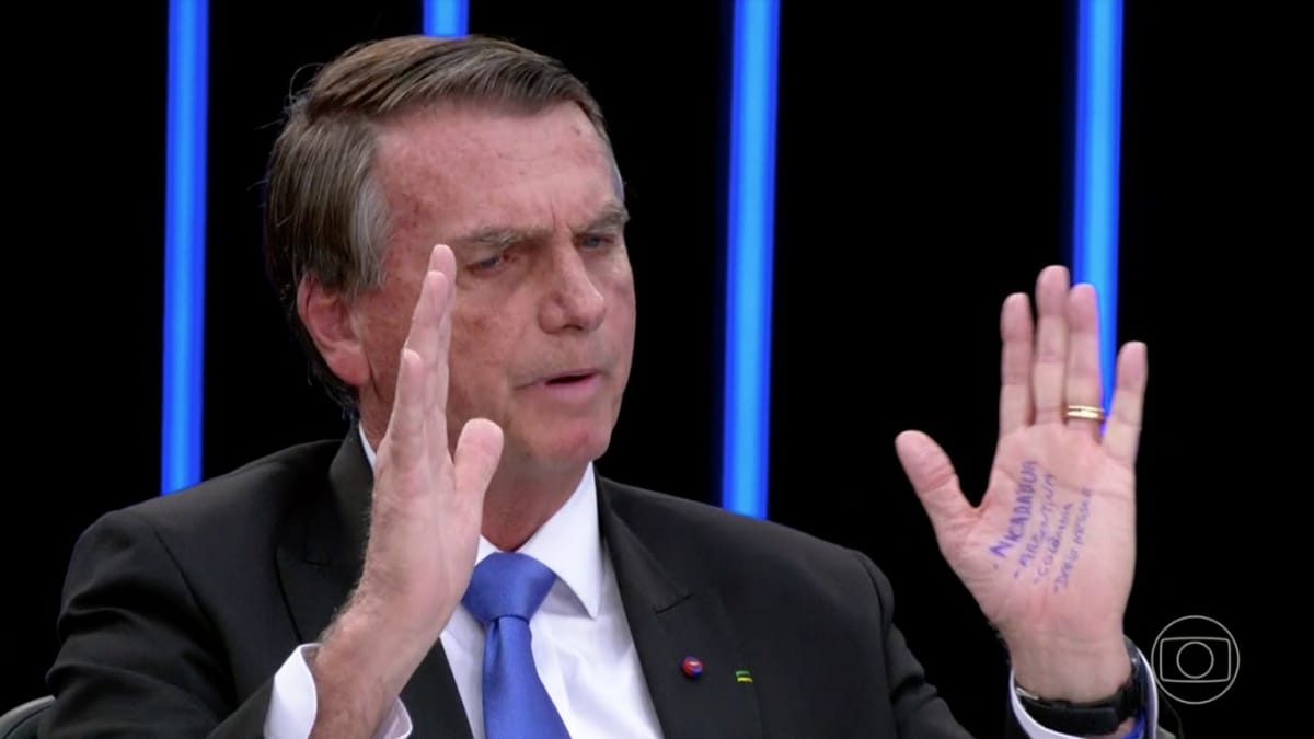 Bolsonaro em trecho da sabatina no Jornal Nacional, com os braços apertos em frente ao rosto