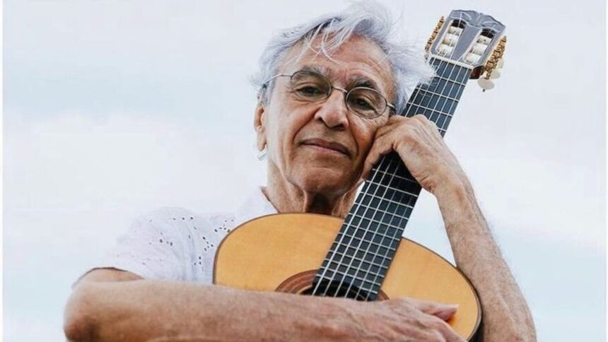 Caetano Veloso abraçando um violão