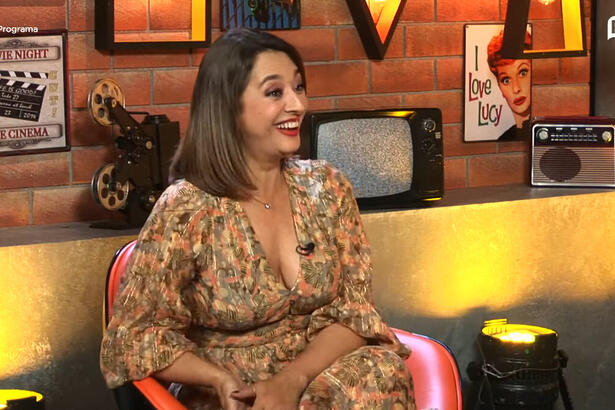 Catia Fonseca sentada em uma poltrona, com um sozinho aberto no rosto, em trecho do Programa de Todos os Programas