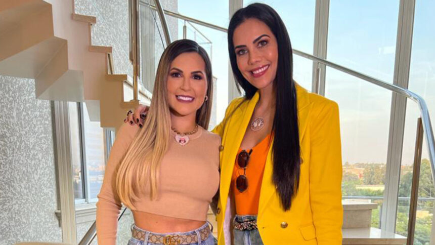 Deolane Bezerra e Daniel Albuquerque abraçadas, em frente a uma escala, em trecho de bastidor do programa Sensacional