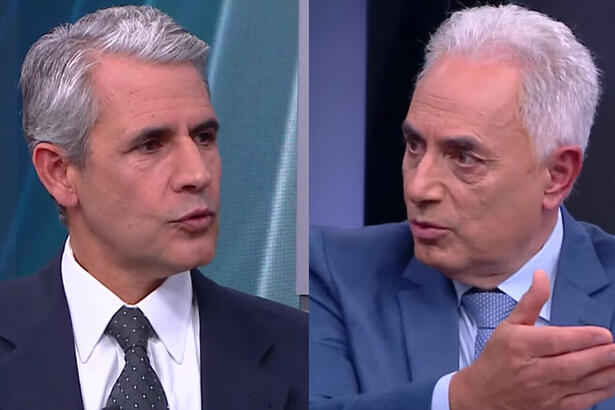 Felipe D'Avila de palitó e gravata preta, camisa social branca, sentado em frente a William Waack; William Waack de blazer cinza, gravaata azul clara e camisa social branca, gesticulando com a mão em frente a Felipe D'Avila durante entrevista na CNN Brasil