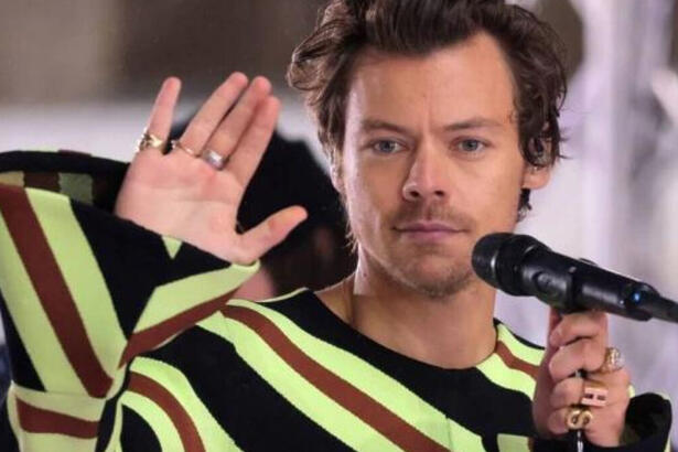 Harry Styles acena com a mão