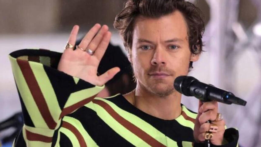 Harry Styles acena com a mão