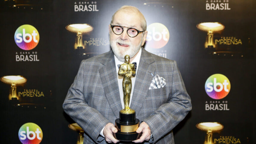 Jo Soares nos bastidores de uma edição do Troféu Imprensa, segurando uma estatueta nas mãos