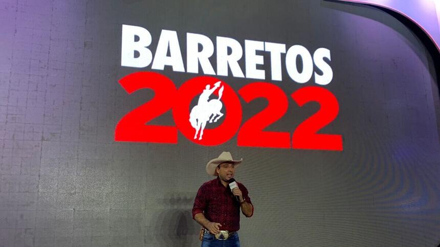 Kléber Oliveira em frente a um banner na Festão do Peão de Barretos