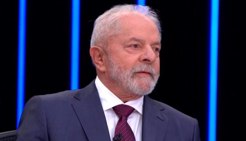 Lula de palitó azul e gravata na cor magenta durante entrevista no Jornal Nacional