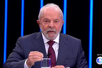 Lula de palitó azul e gravata na cor majenta durante entrevista no Jornal Nacional