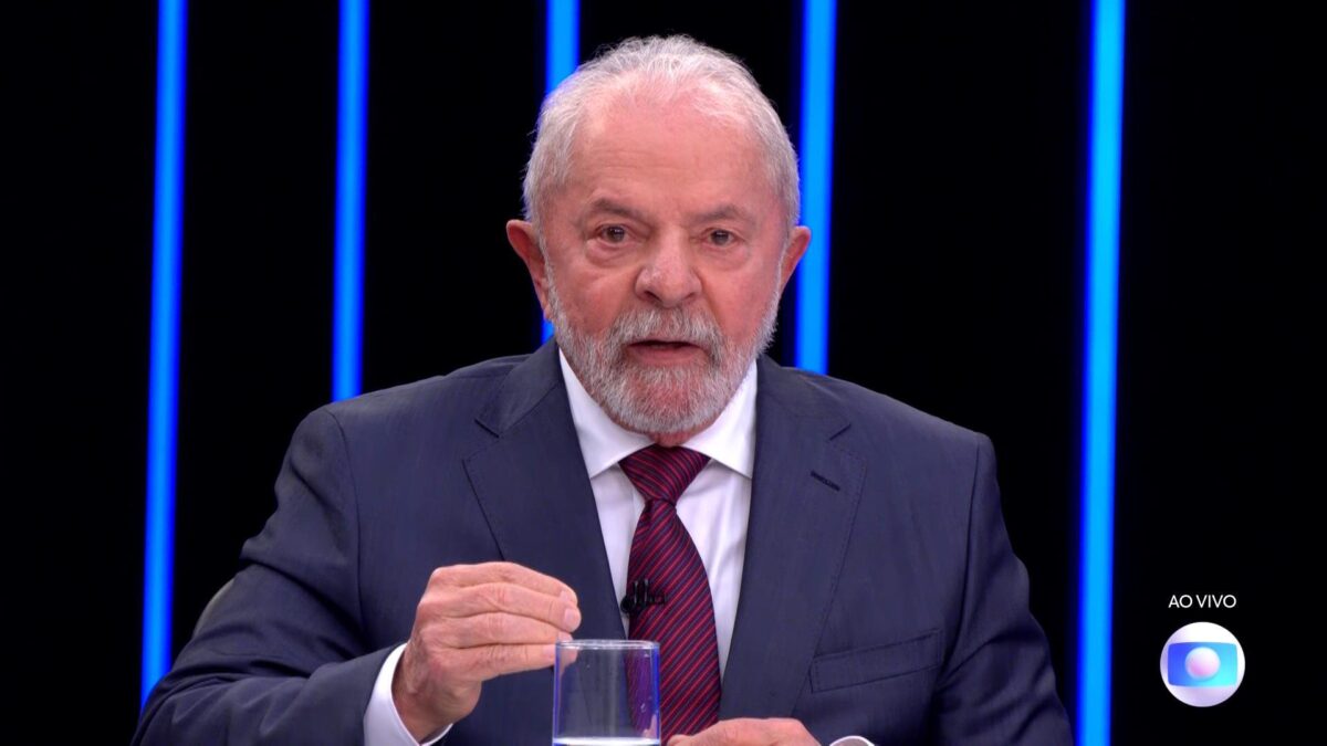 Lula de palitó azul e gravata na cor majenta durante entrevista no Jornal Nacional