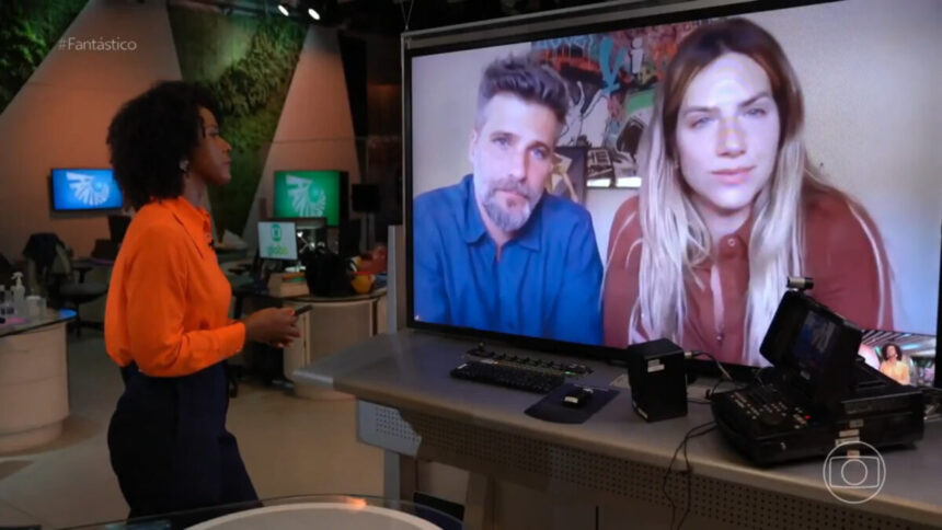 Maju Coutinho, em entrevista por videoconferencia com Giovanna Ewbank e Bruno Gagliasso. Eles aparecem em um televisor, posicoonado a frente da apresentadora