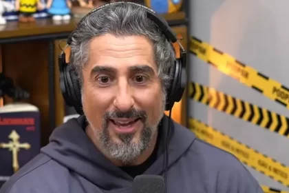 Marcos Mion surpreso durante entrevista no Podpah, no Yotube; Apresentador usa camisa cinza com capuz e fone de ouvido