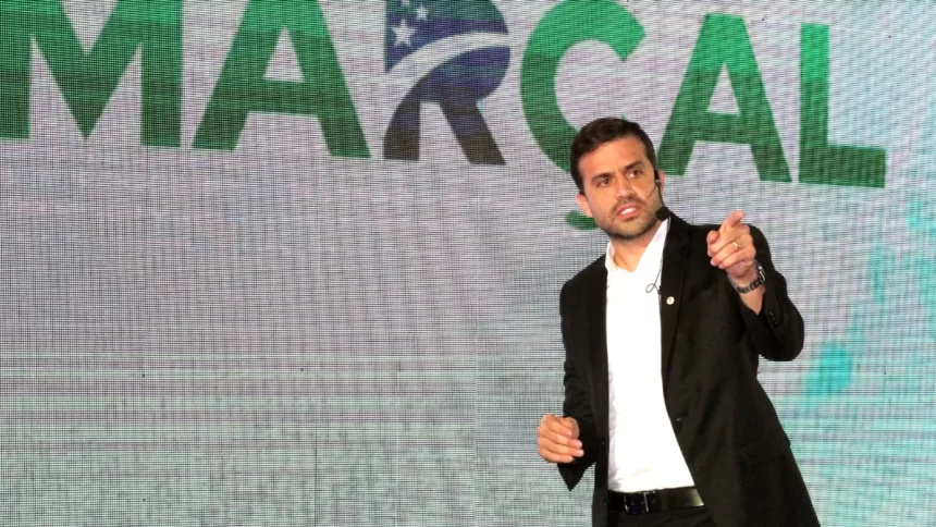 Pablo Marçal em um evento oficial do Pros, em frente a um telão