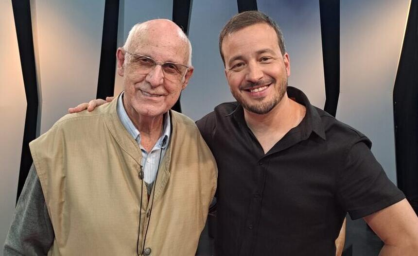 Padre Julio Lancellotti de camisa marrom, com flash no meio, de óculos, sorrindo, ao lado de Rafael Cortez de camisa manga longa preta, sorrindo, durante gravação do Matéria Prima, da TV Cultura