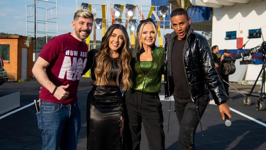 Rudy Landucci de camisa vermelha e estampa branca, calça jeans; Lauana Prado de vestido preto sorrindo, cabelo solto; Eliana de camisa verde e calça preta, sorrindo, de cabelo preto; Ney Lima de jaqueta de couro preta, camisa e calça jeans prata; todos abraçados durante gravação do Programa Eliana