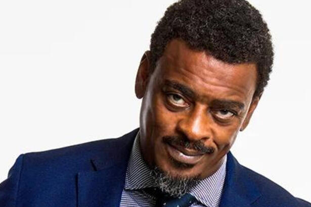 Seu Jorge de terno e gravata azuis