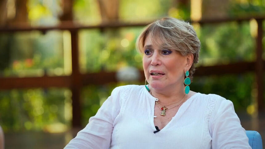 Susana Vieira em trecho da entrevista para o Fantástico. Ela está sentada em uma poltrona, no jardim de sua residência