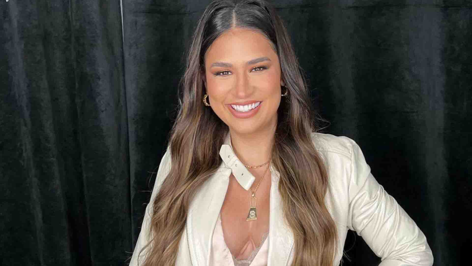 Simone Mendes em foto posada à frente de um fundo preto. Ela está com sorriso aberto no rosto