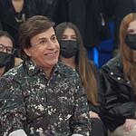 Tom Cavalcante vestindo uma camisa camuflada está sorrindo no palco do Altas Horas