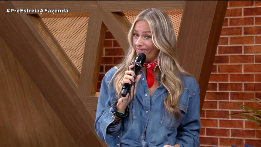 Adriane Galisteu com o microfone em mãos participando da Pré-Estreia de A Fazenda 14