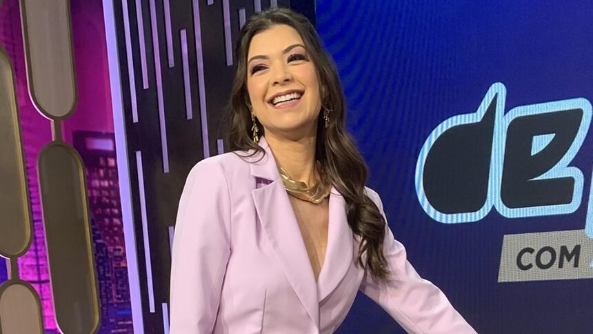 Amanda Françozo de vestido rosa clar sorrindo durante gravação do De Papo com Amanda Françozo, da TV Aparecida