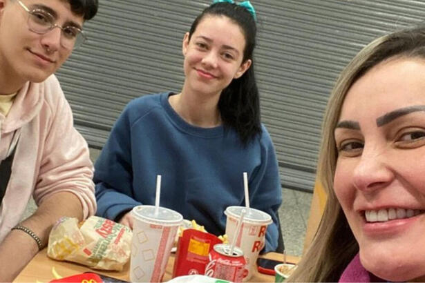 Andressa Urach, Arthur Urach e Brenda comendo um lanche em uma rede de fast food