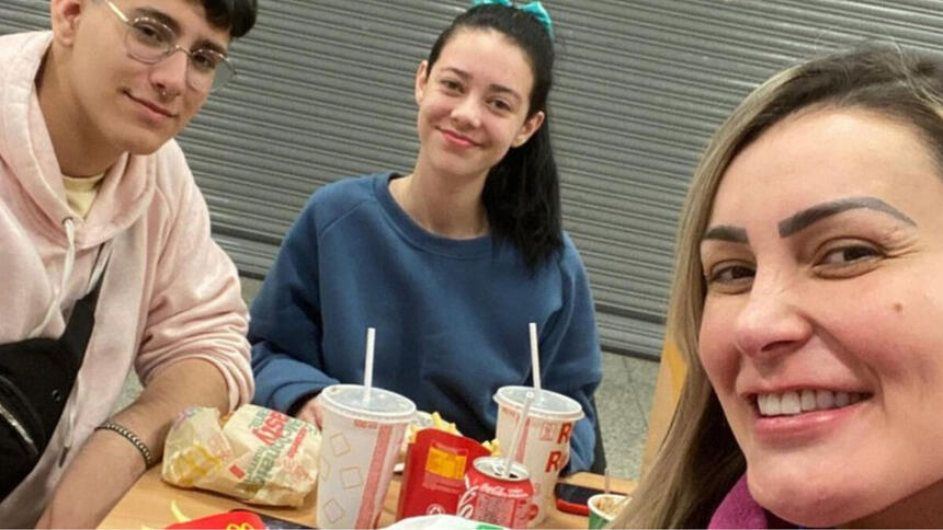 Andressa Urach, Arthur Urach e Brenda comendo um lanche em uma rede de fast food