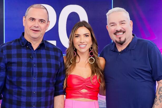 Bola de camisa lisa na cor azul marinho ao lado de Patricia Abravanel de camisa vermelha e calça rosa ao lado de Carioca com camisa estampada nas cores azul e preta durante gravação do programa Silvio Santos, do SBT