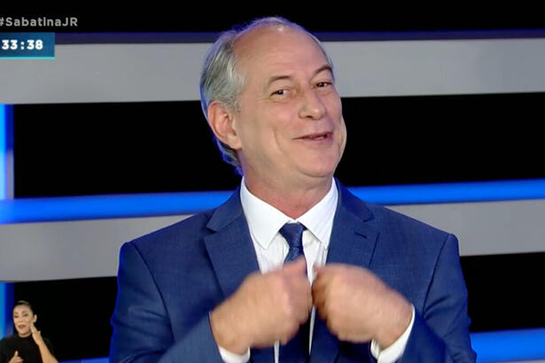 Ciro Gomes com a mão na gravata, sorrindo, durante entrevista na Record TV