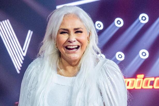 Fafá de Belém de vestido branco, de cabelo solto, sorrindo, durante gravação do The Voice+, da TV Globo