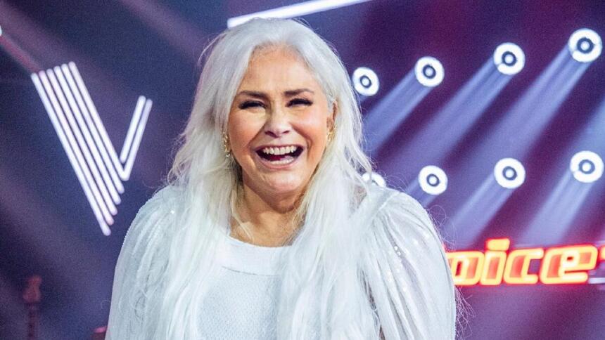 Fafá de Belém de vestido branco, de cabelo solto, sorrindo, durante gravação do The Voice+, da TV Globo