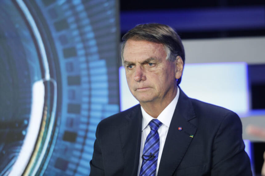 Jair Messias Bolsonaro de palitó preto, gravata azul com semblante sério durante entrevista na Record TV