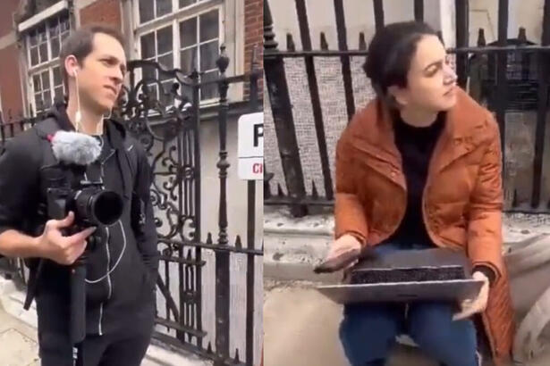 Jornalistas da BCC Brasil atacados em Londres, em frente a um portão com um câmera e um notebook em mãos