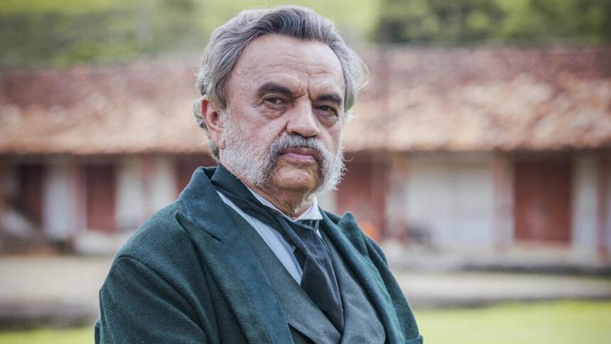 José Dumont de palito, gravata e colete preto usando barba e cabelo branco durante gravação de velho chico, da tv globo