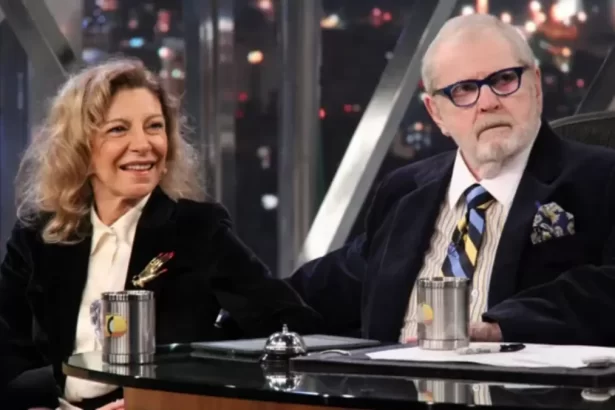 Marília Pêra de blazer preto, camisa social branca sorrindo, sentada ao lado de jô soares durante gravação