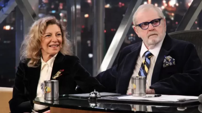 Marília Pêra de blazer preto, camisa social branca sorrindo, sentada ao lado de jô soares durante gravação