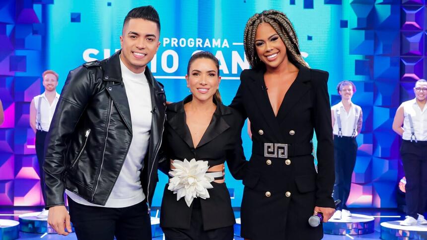 Raffa Augusto de jaqueta de couro, camisa branca, calça jeans preta sorrindo ao lado de Patricia Abravanel e Marvvila de vestido preto