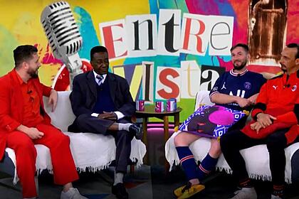 Mauricio Meirelles de blazer e calça vermelha, sentado num sofá branco junto aos sósias de Pelé e Messi durante gravação do Foi Mau, da RedeTV!